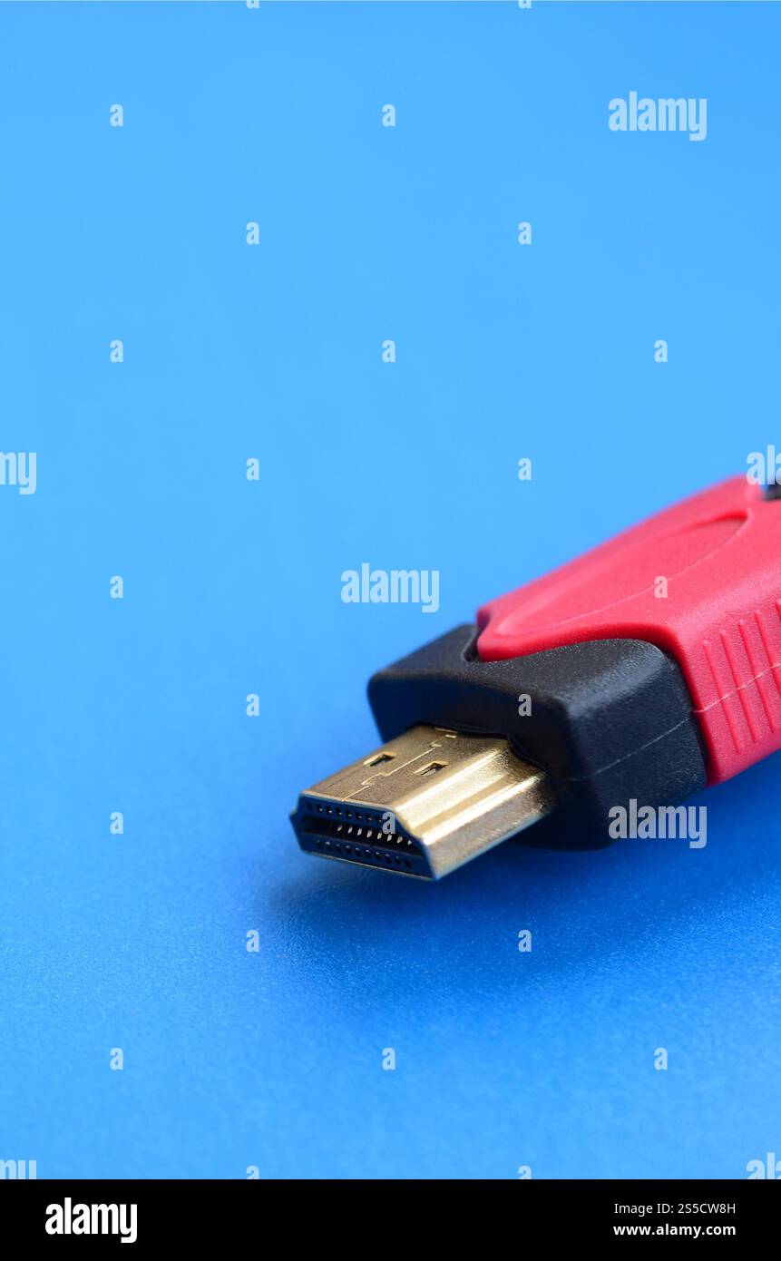 Black audio video HDMI computer cable on blue background. Close up of home entertainment connection cable for sound and video Stock Photo