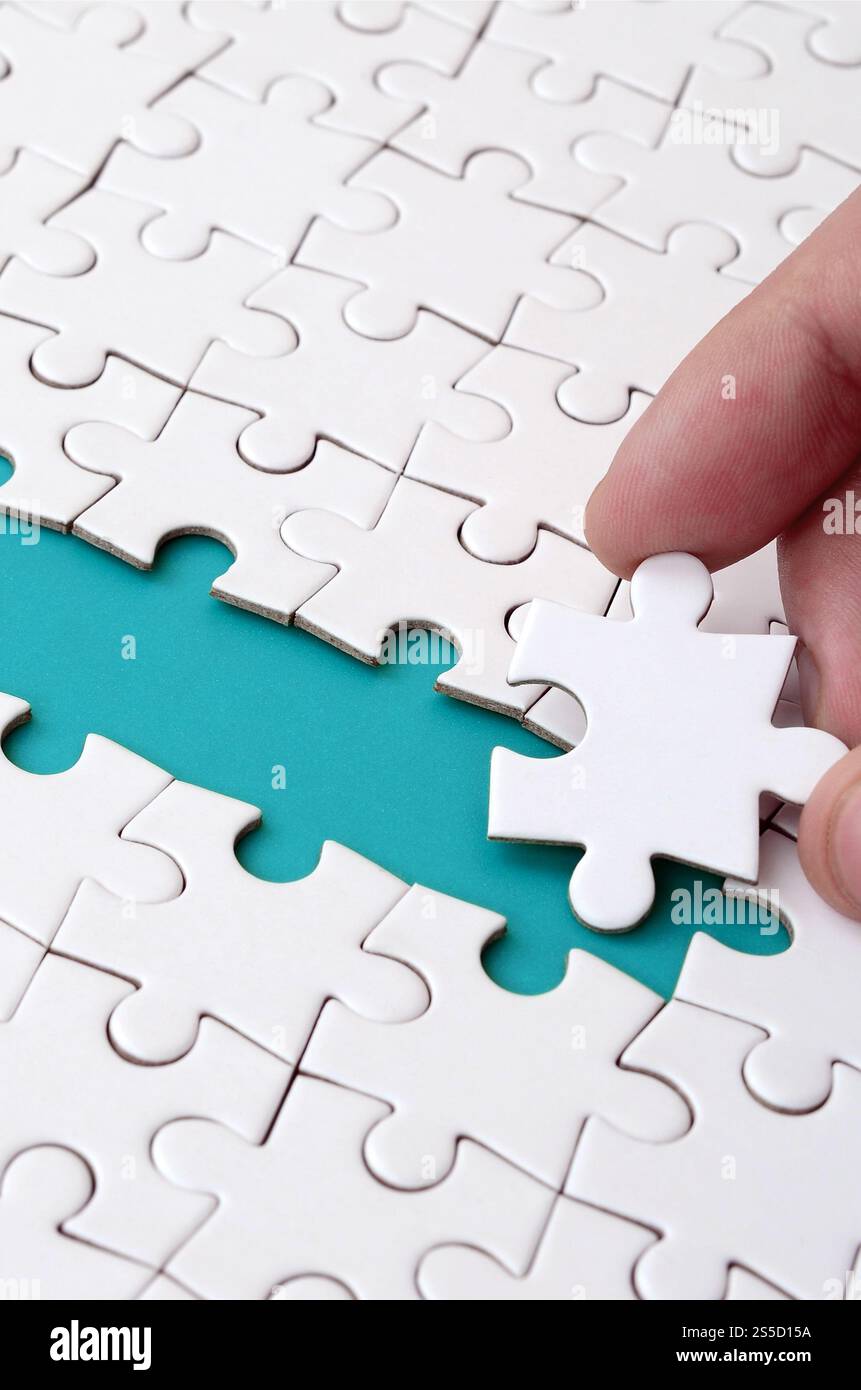 The human hand paves the way to the surface of the jigsaw puzzle The human hand paves the way to the surface of the jigsaw puzzle