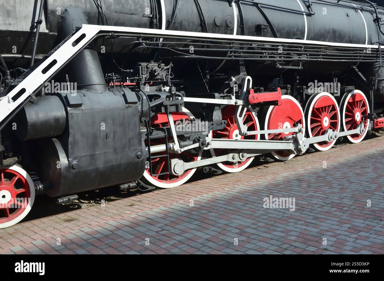 Wheels of the old black steam locomotive of Soviet times. The side of ...