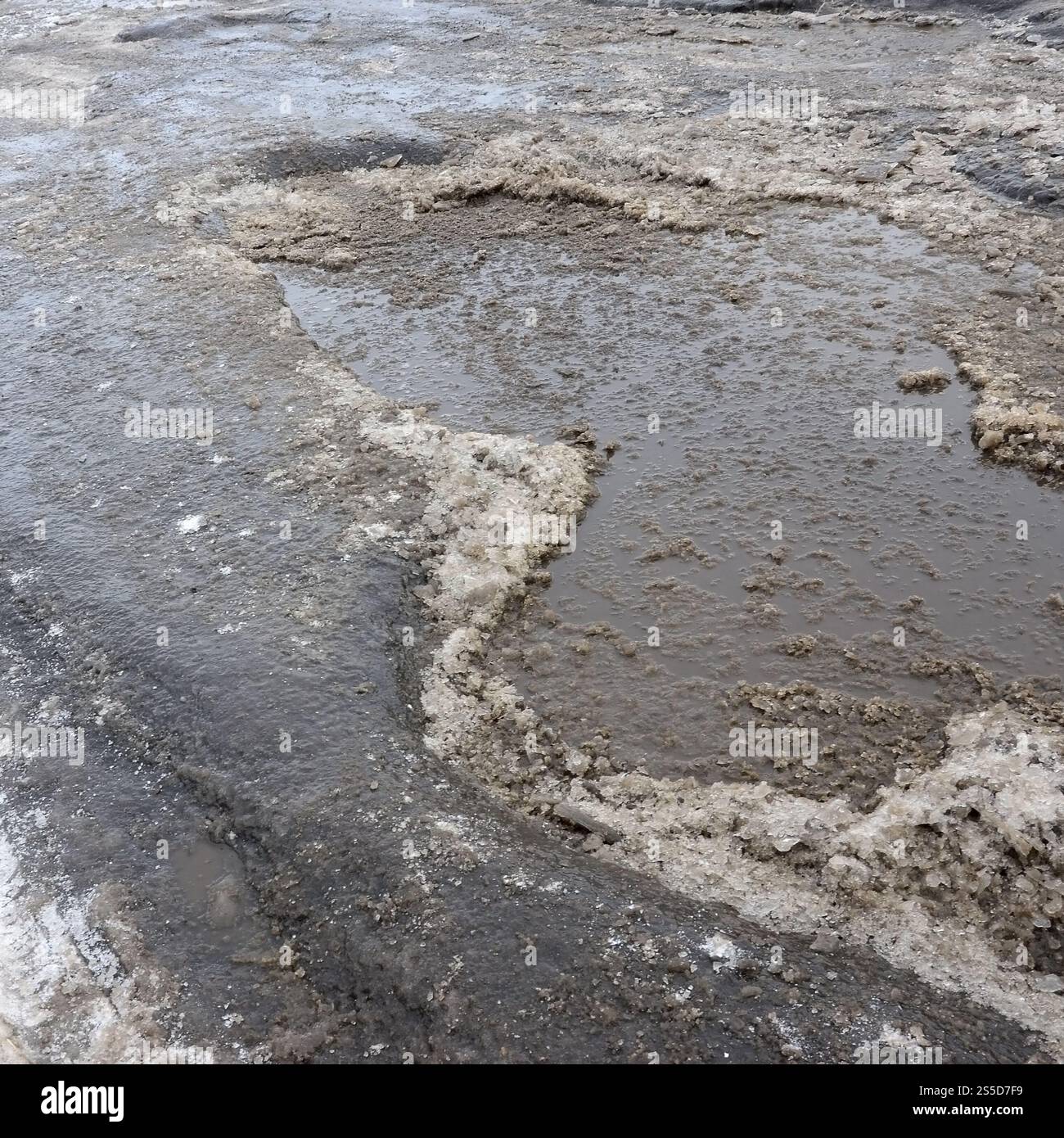 Freezing Roard Condition Damaged asphalt road with potholes caused by freezing and thawing ...
