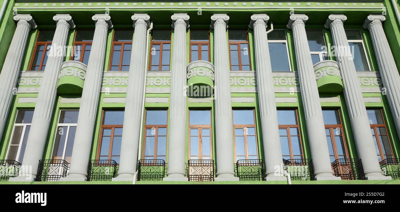 Restored old multi-storey building with antique columns, painted in ...