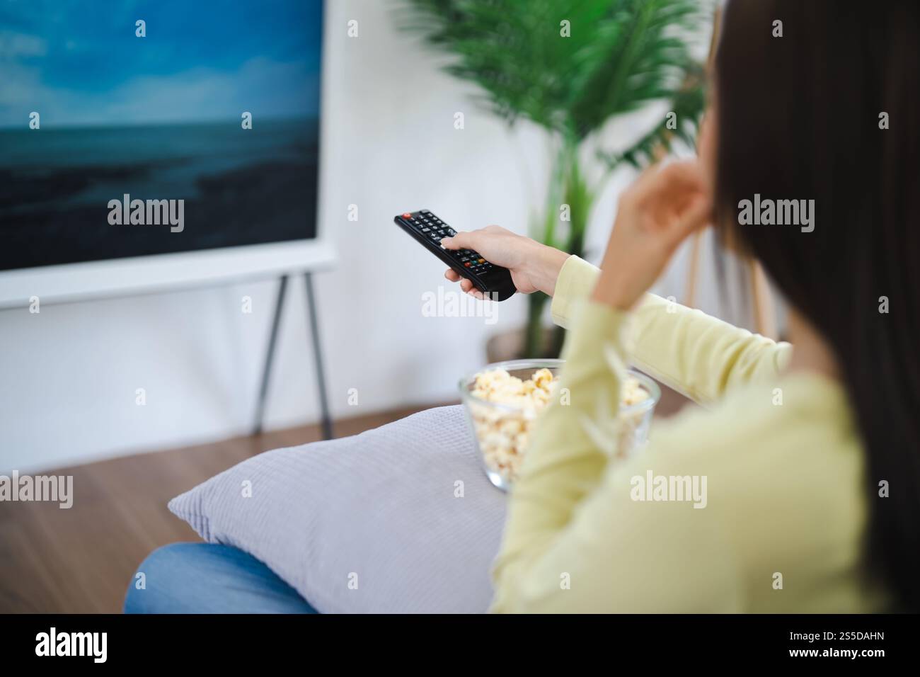Asian woman Watching smart TV and using remote controller Hand holding ...