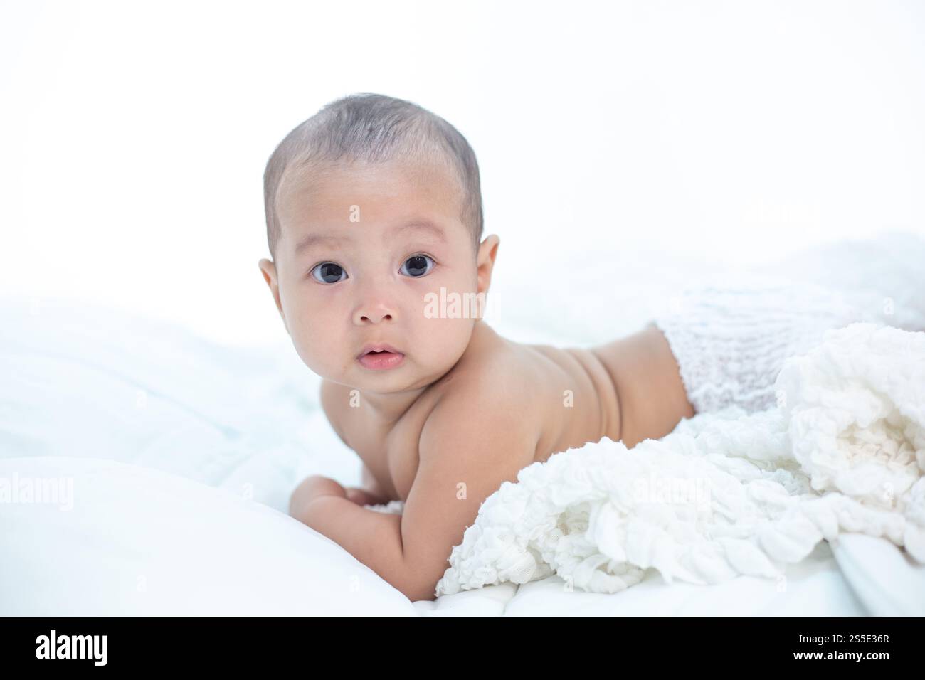 Cute little baby looking into the camera Stock Photo - Alamy