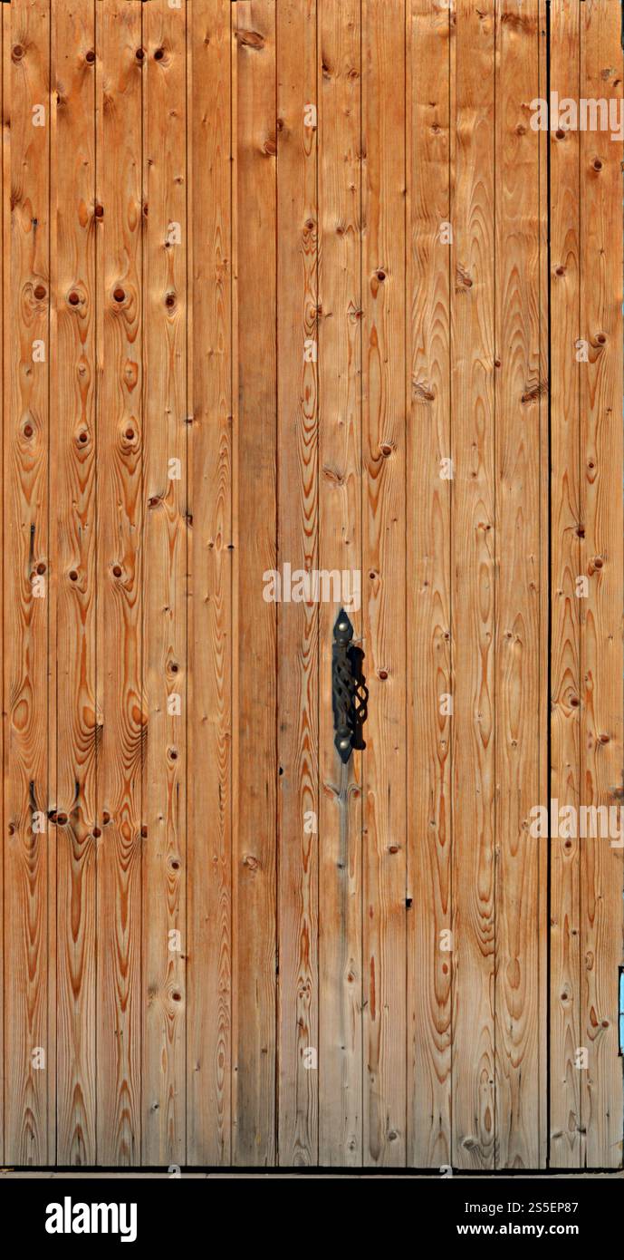 Boarded up old yellow wooden door texture with forged metal black handle. Wooden door texture Stock Photo