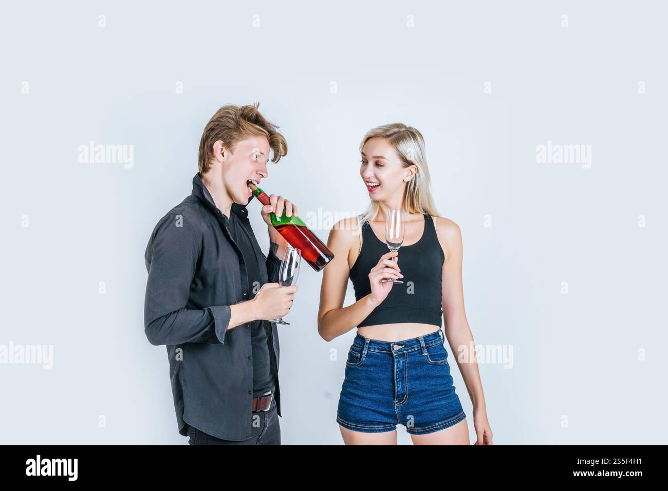 Portrait of happy young couple drinking wine in studio Stock Photo