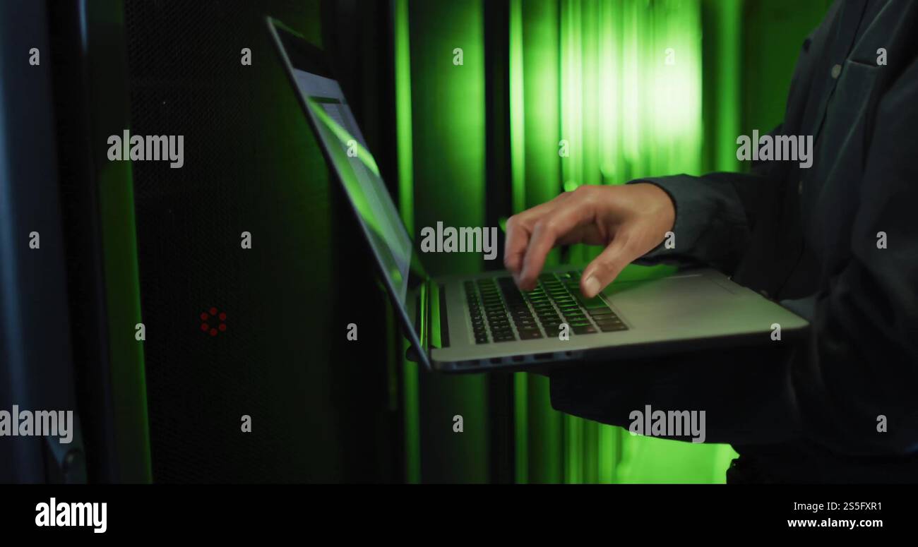 Image of man using laptop over computer servers Stock Photo