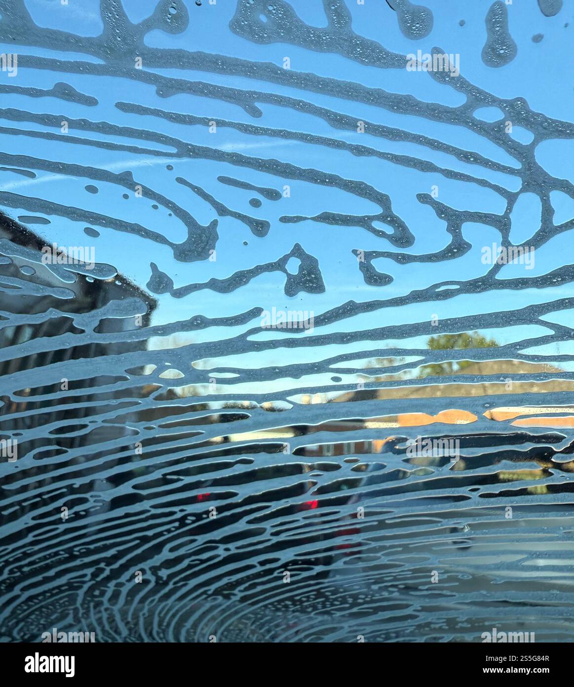 Foamy water on a car windscreen/windshield in a car wash - Smartphone Captured Stock Image