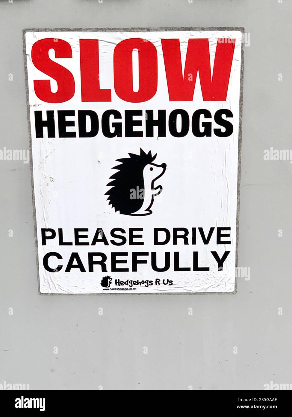 Humorous roadside warning sign urging drivers to slow down for hedgehogs in Northampton England coloured picture - Smartphone Captured Stock Image