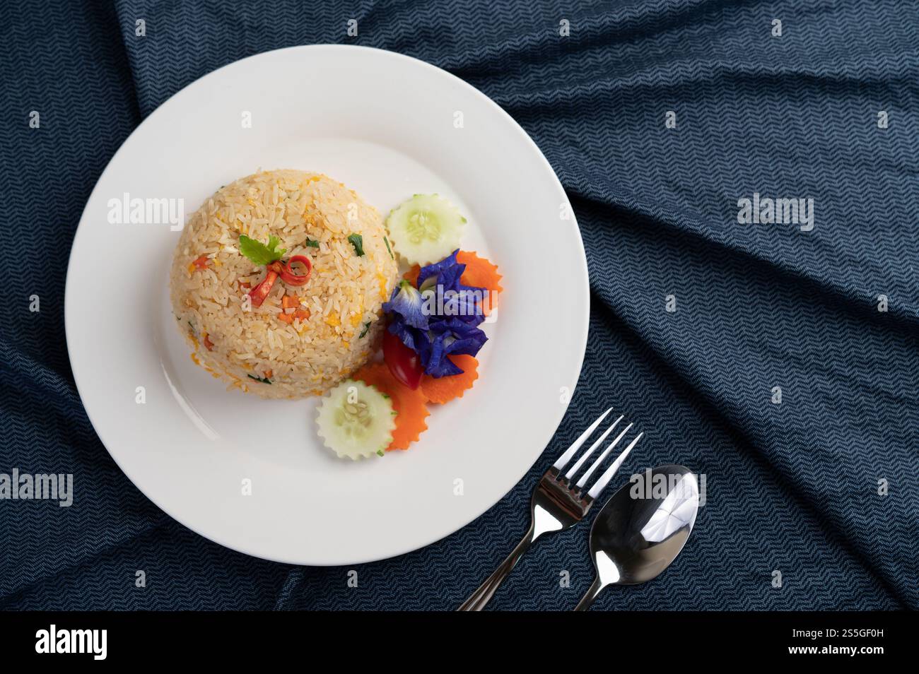 Egg fried rice on a white plate, wrinkled fabric. Stock Photo