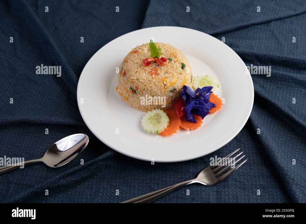 Egg fried rice on a white plate, wrinkled fabric. Stock Photo