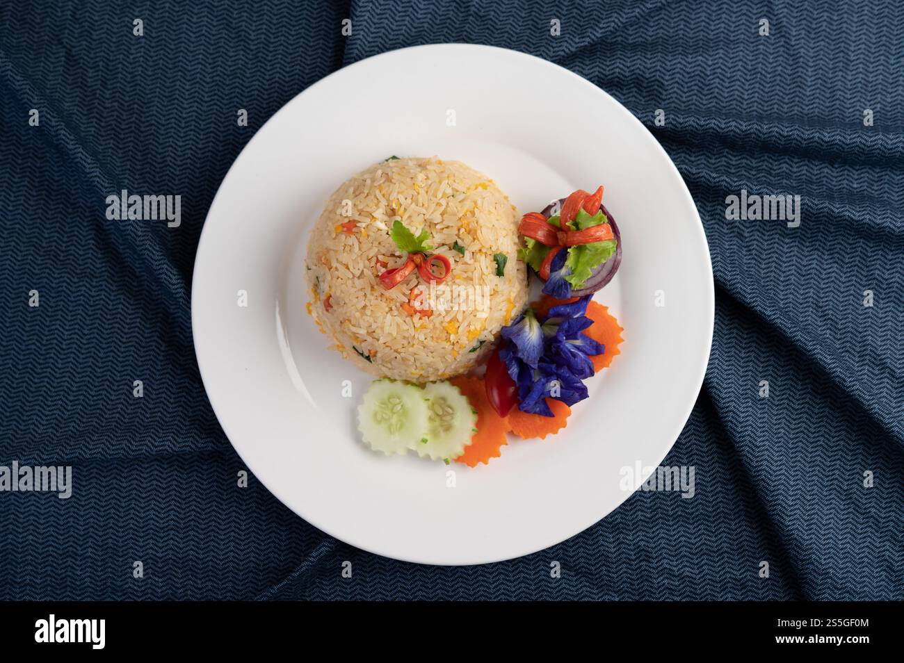 Egg fried rice on a white plate, wrinkled fabric. Stock Photo