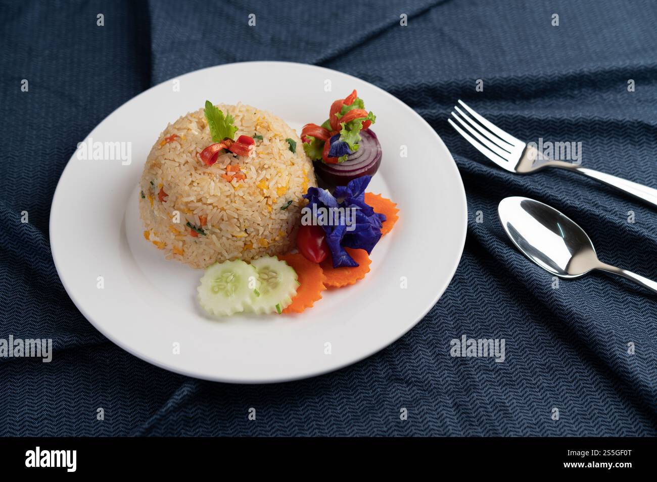 Egg fried rice on a white plate, wrinkled fabric. Stock Photo