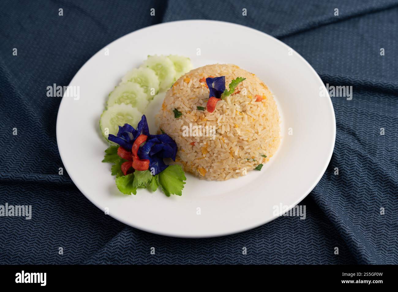Egg fried rice on a white plate, wrinkled fabric. Stock Photo