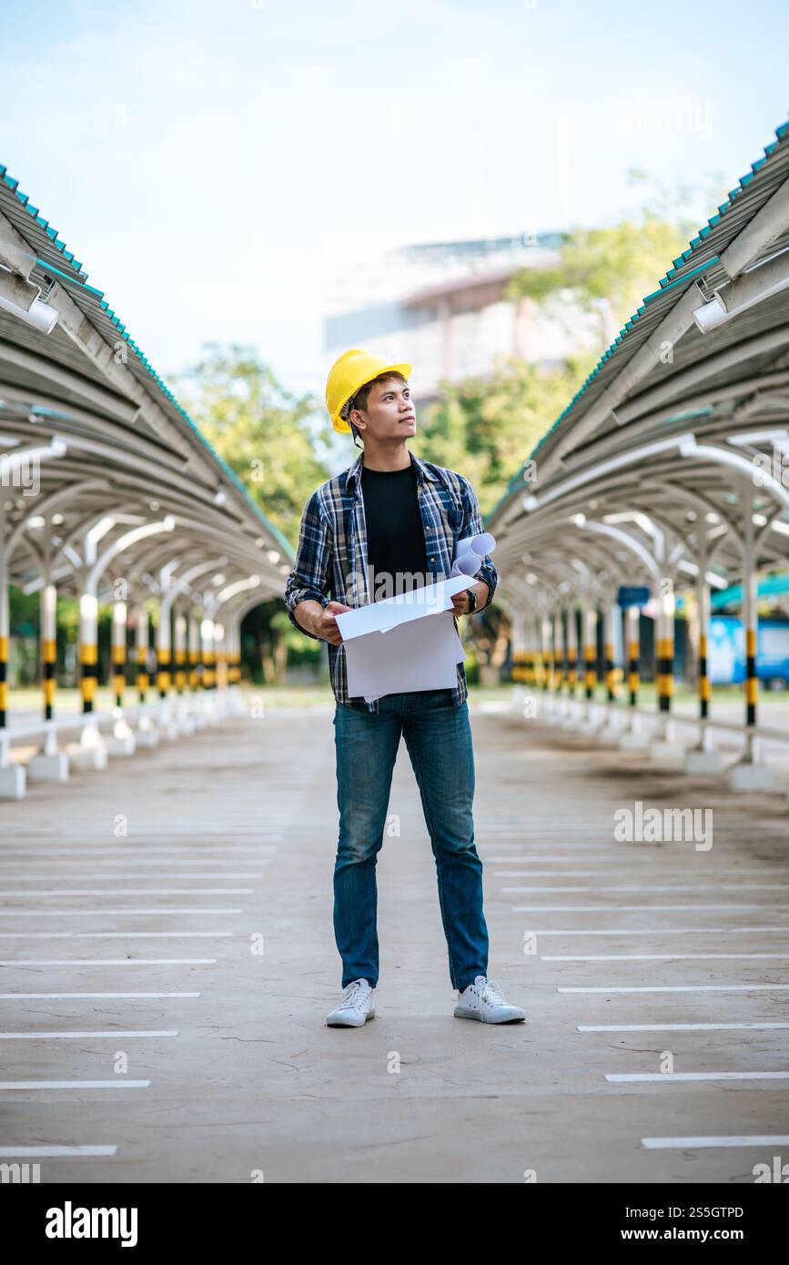 Architects hold the building plan and check the work Stock Photo - Alamy
