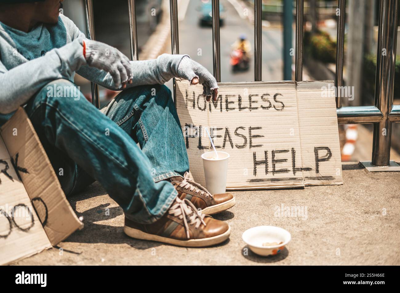 The man sitting begging on an overpass with messages homeless people ...