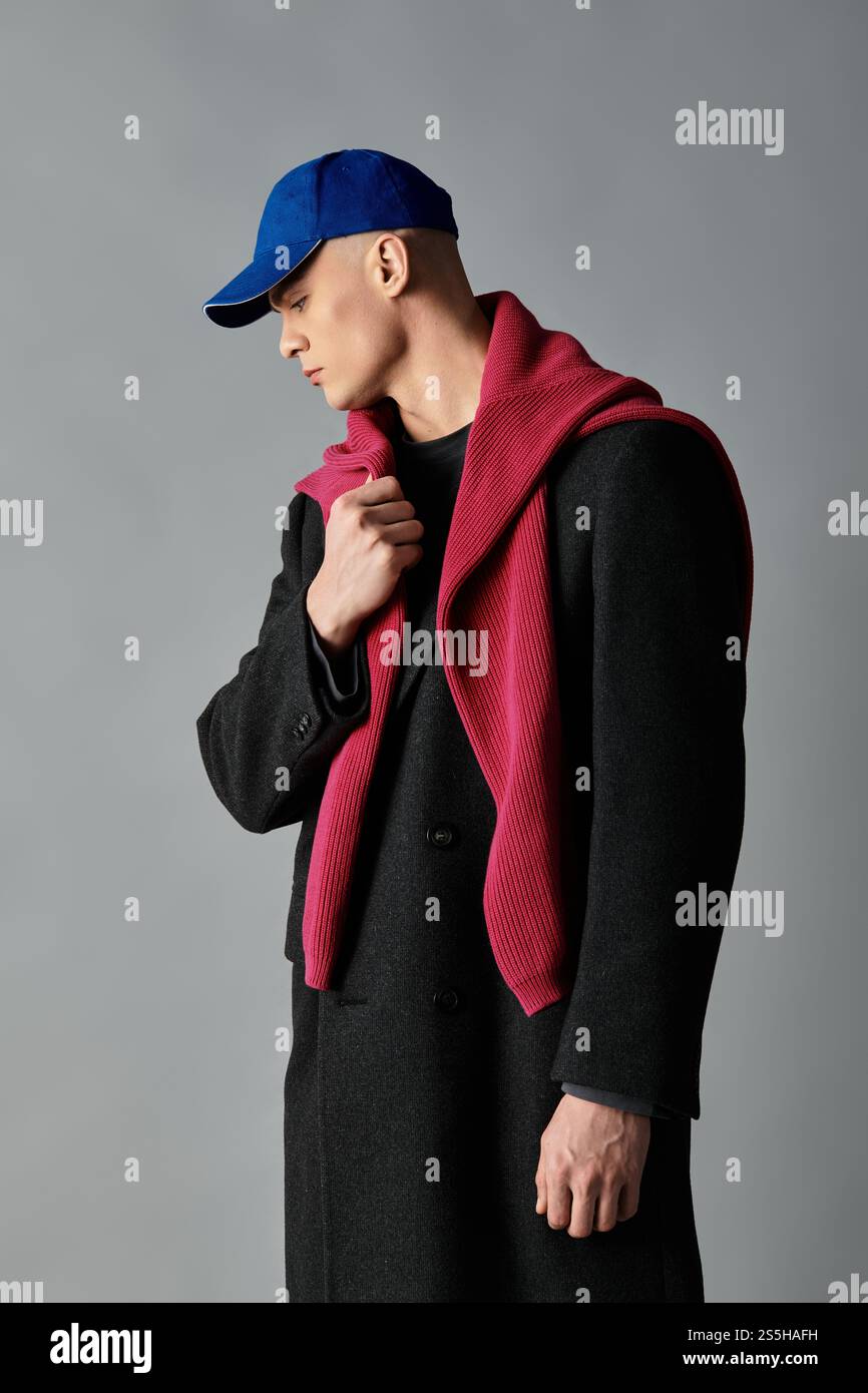 A young man with a stylish cap and scarf showcases a contemporary ...