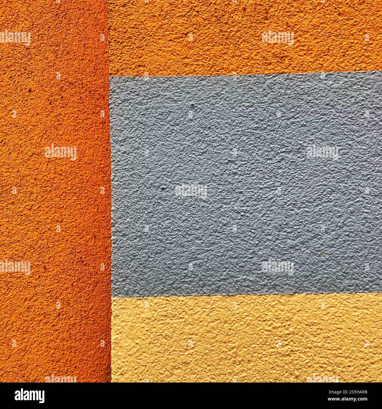 Abstract photograph of a wall with textured distinctly colored blocks, creating a modern geometric composition. - Smartphone Captured Stock Image
