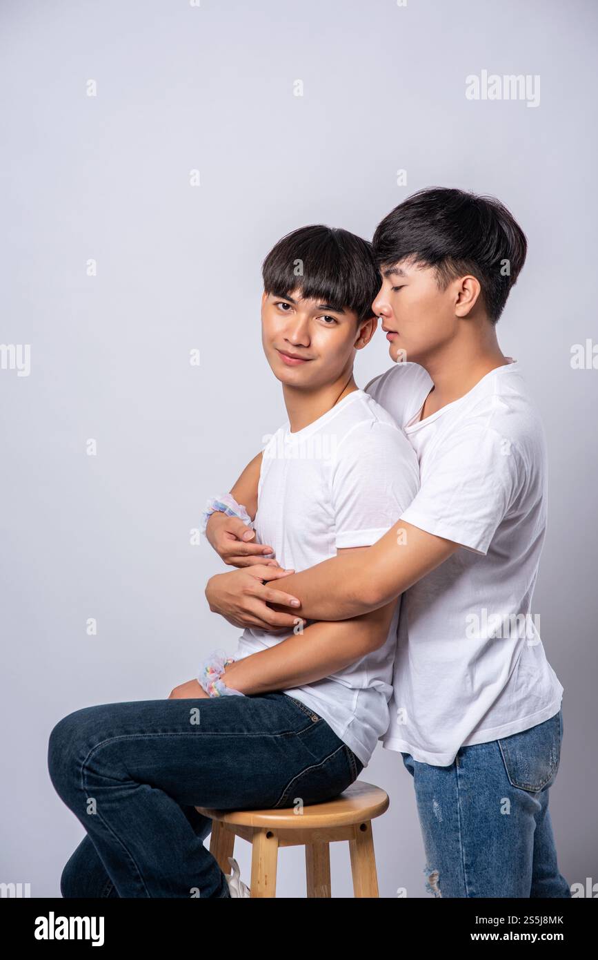 Two men who love each other hug and sit on a chair Stock Photo - Alamy