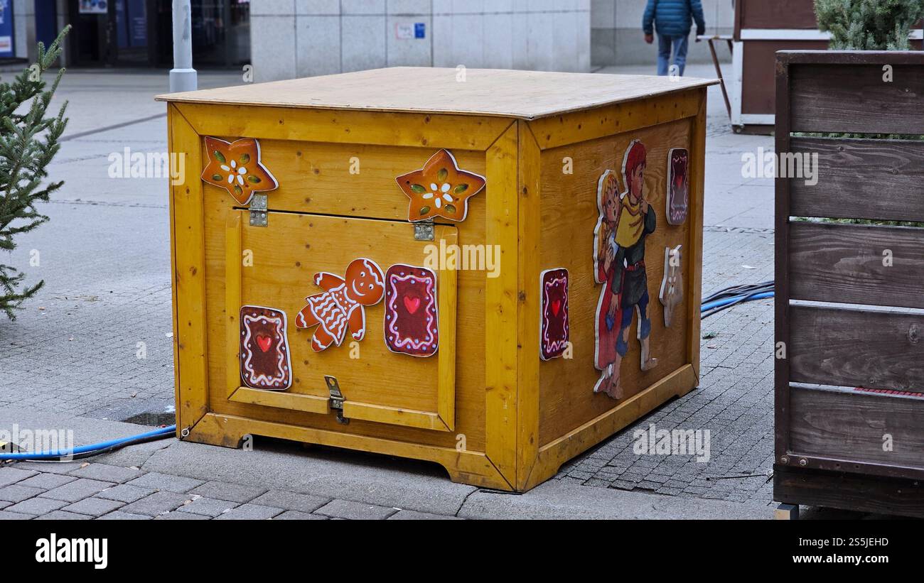 Wooden utility box decorated with gingerbread man and Christmas market motifs on a city street. - Smartphone Captured Stock Image