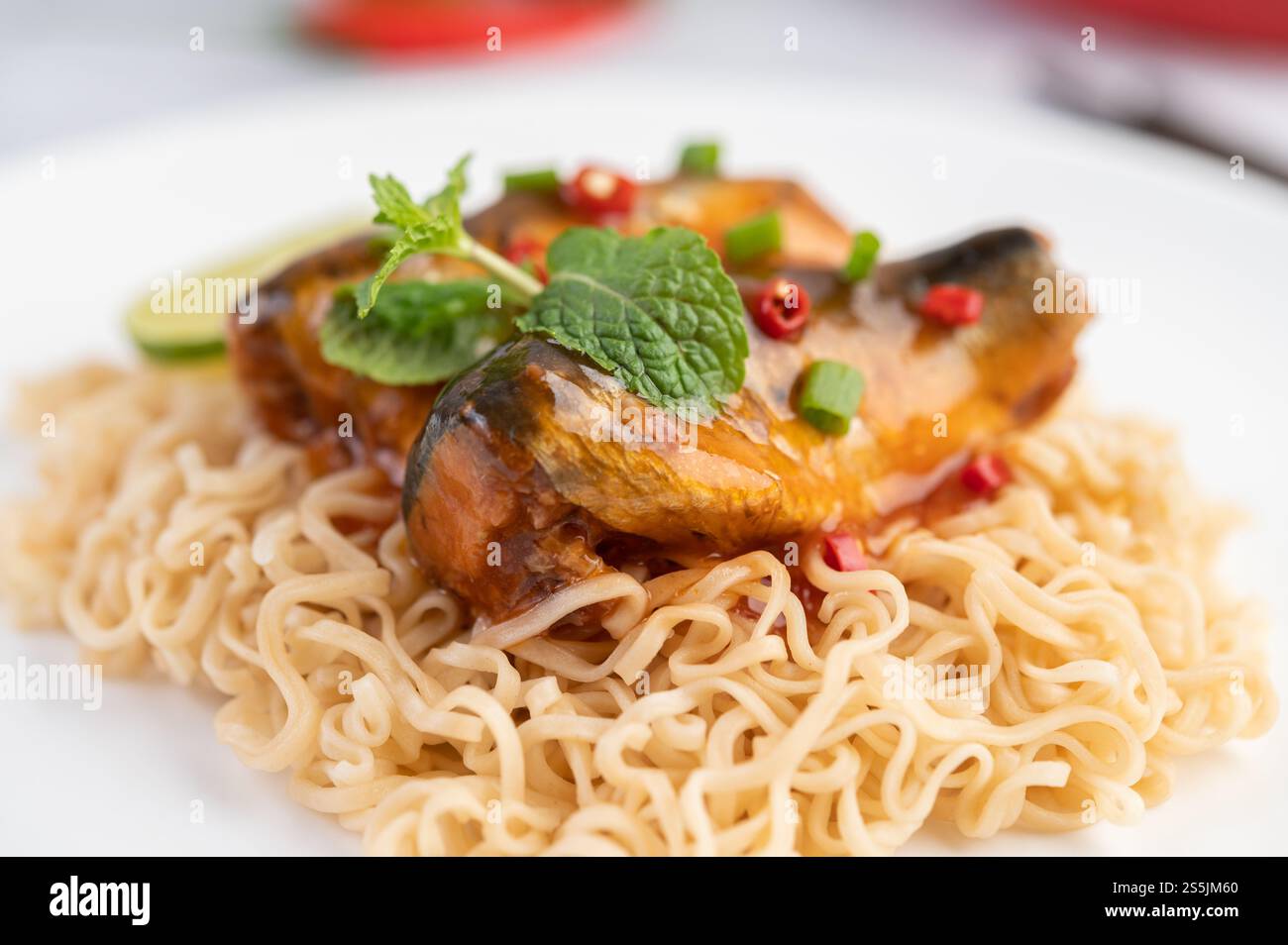 Mama and canned fish in a white dish with lemon Peppermint and chili. Stock Photo