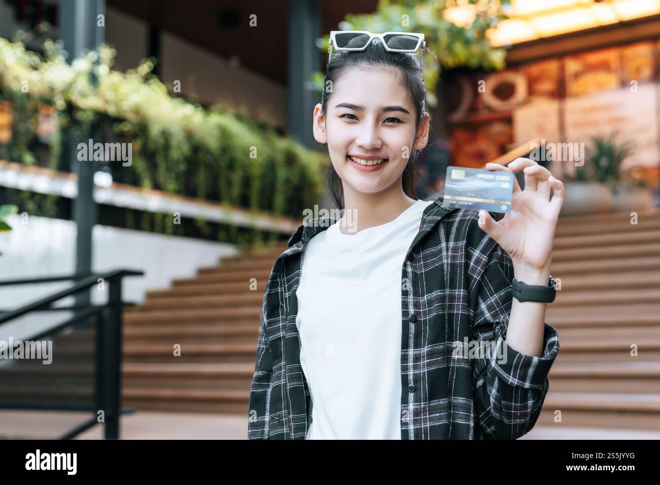 Portrait of young Asian woman wearing eyeglasses standing on stairs ...