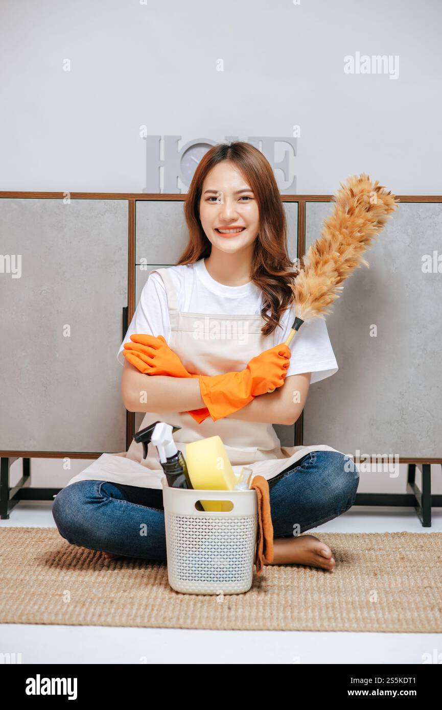 Portrait cheerful woman wearing apron and rubber gloves during cleaning ...
