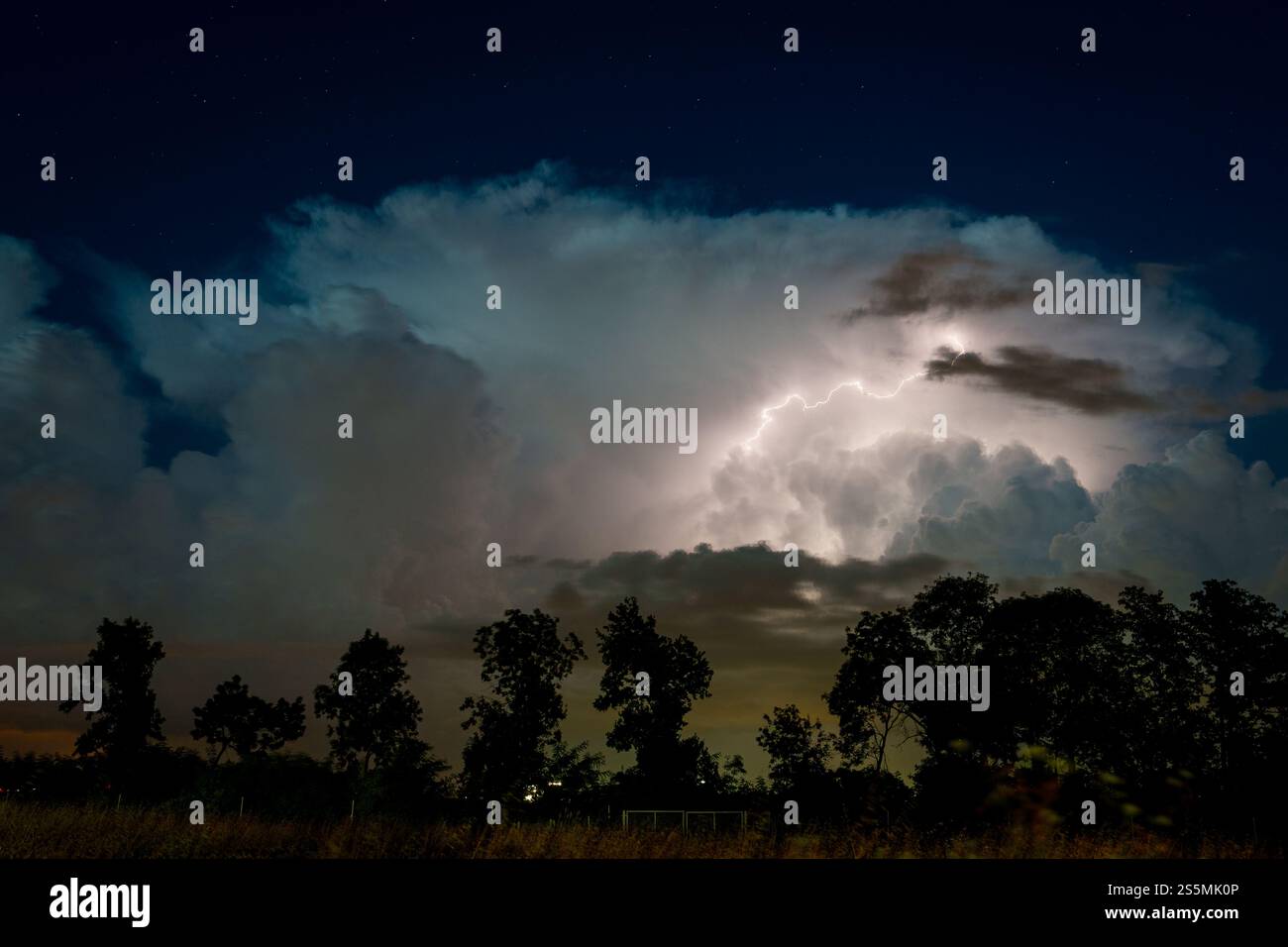 Nighttime sky illuminated by a bolt of lightning over the horizon Stock ...