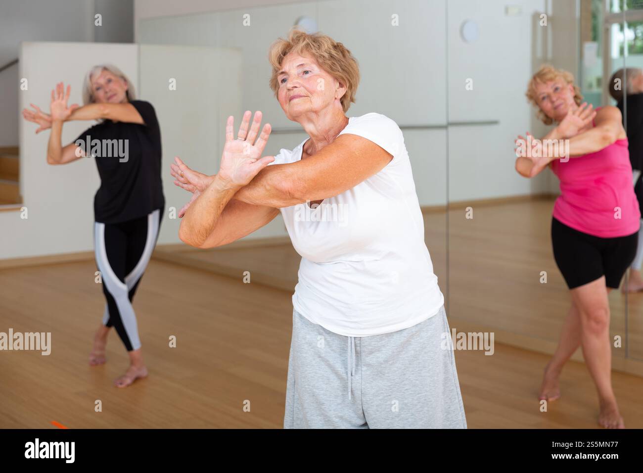 Energetic elderly woman practicing vigorous dance movements Stock Photo