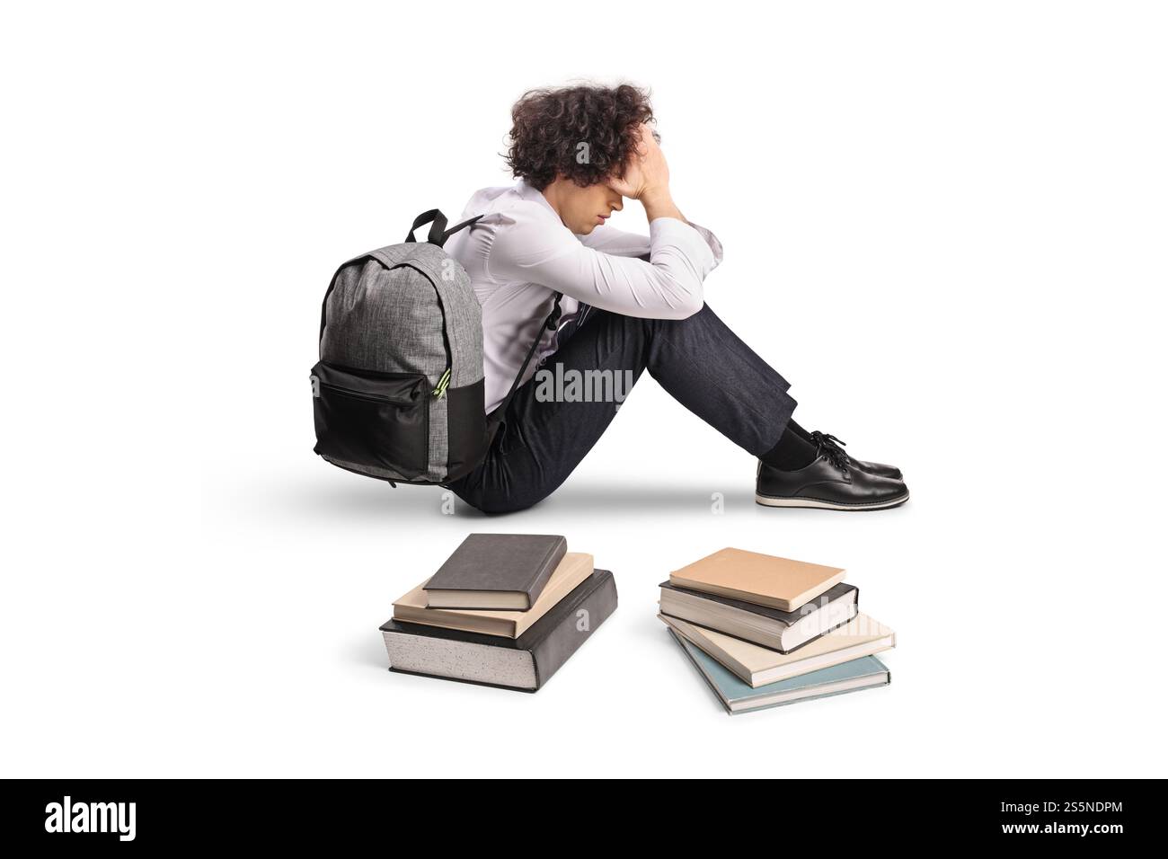 Unhappy male student with a backpack and books on the floor isolated on ...
