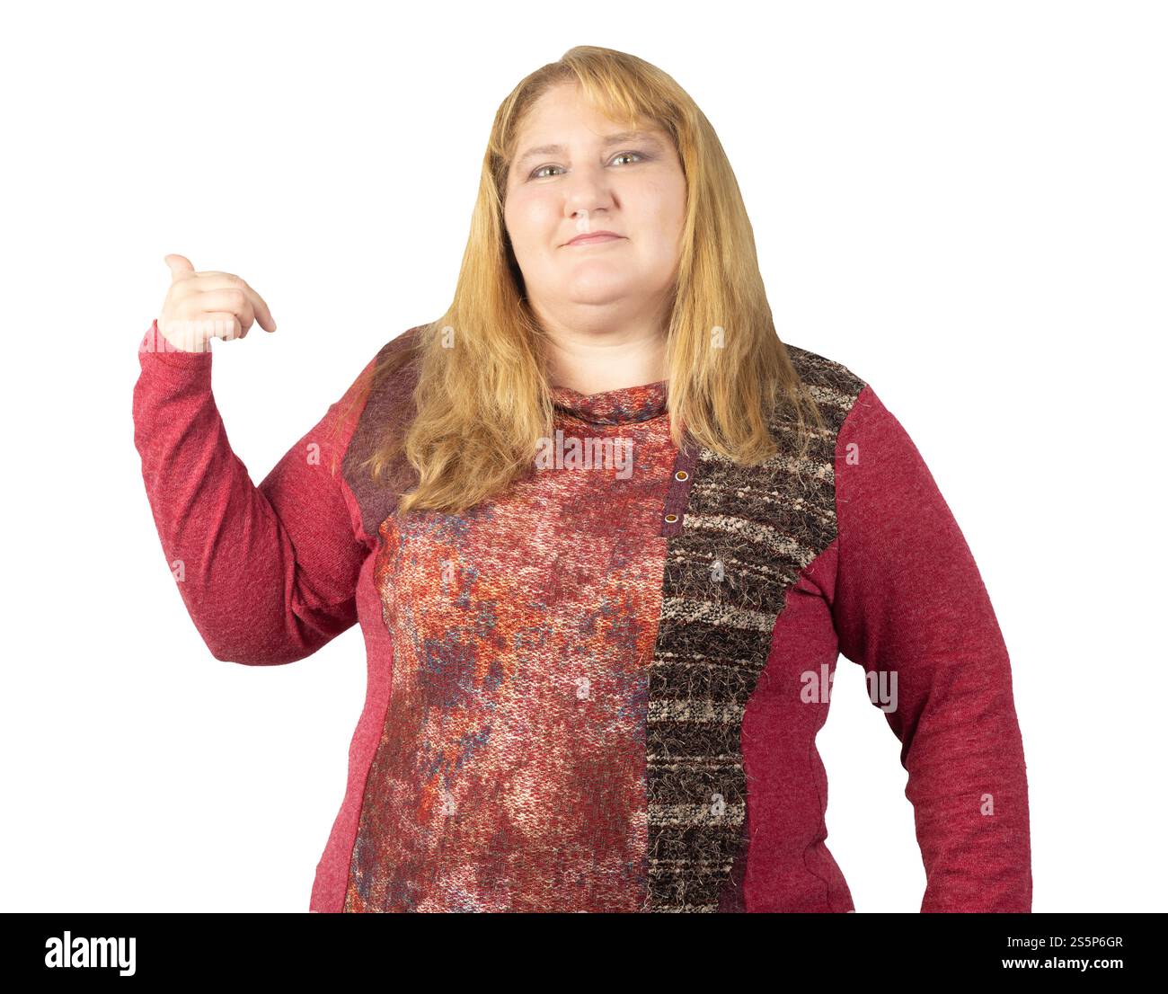 A middle-aged woman confidently gesturing with her hand, maintaining a composed expression. She is wearing a red patterned sweater Stock Photo