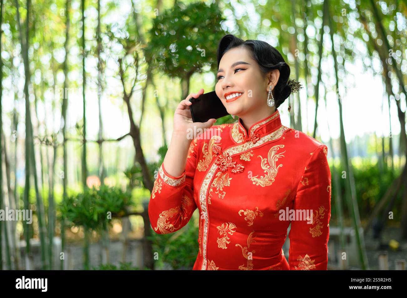 Portrait pretty Asian woman in a Chinese cheongsam smile while talking ...