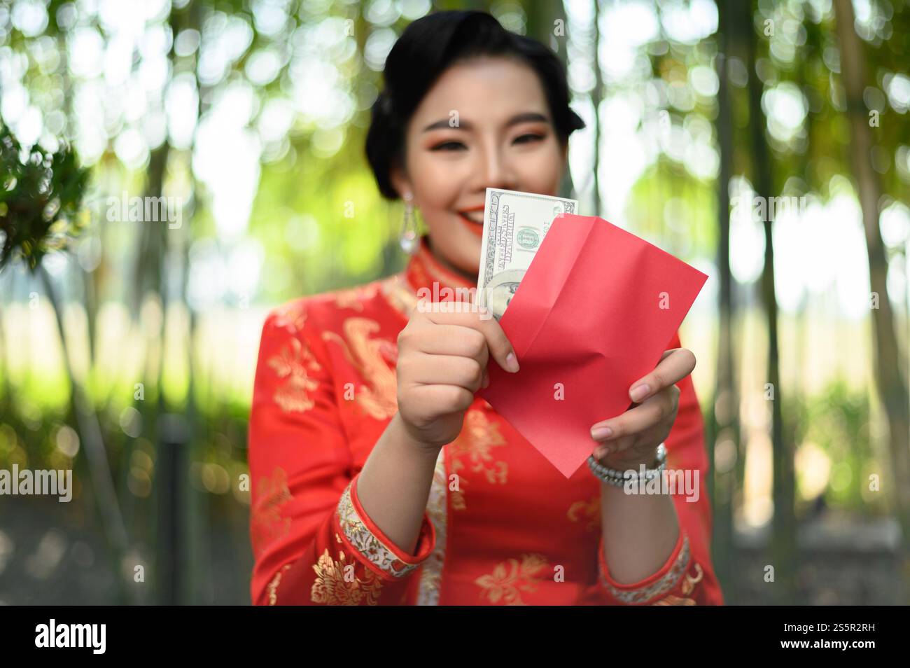 Portrait pretty Asian woman in a Chinese cheongsam holding envelopes ...