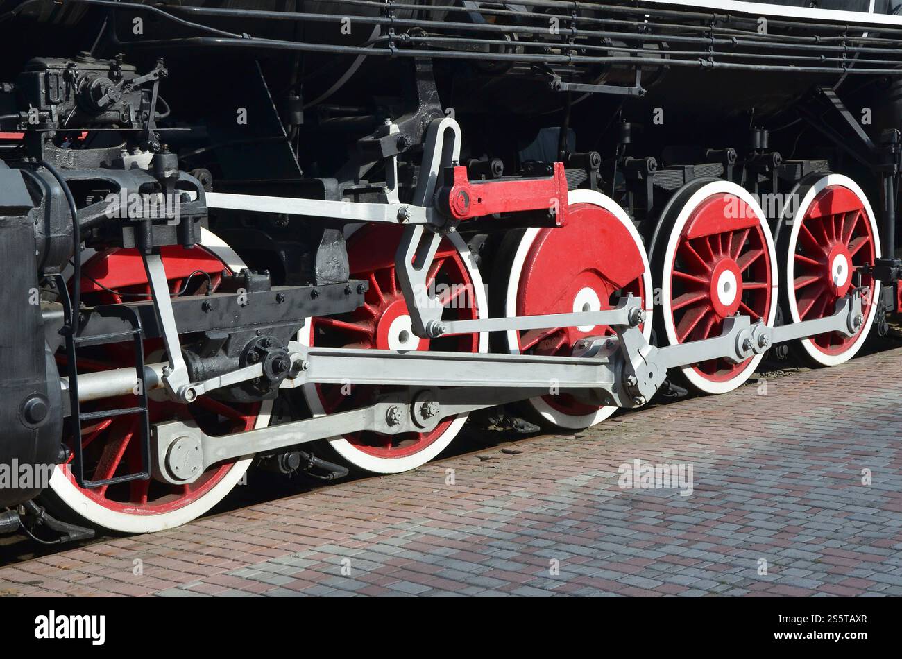 Wheels of the old black steam locomotive of Soviet times. The side of ...