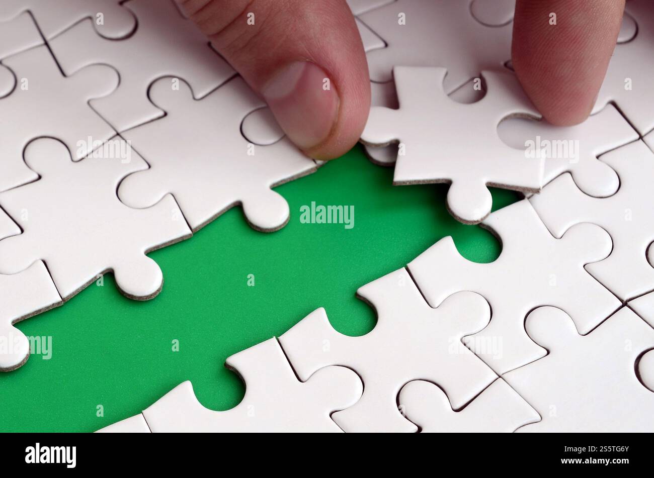 The human hand paves the way to the surface of the jigsaw puzzle The human hand paves the way to the surface of the jigsaw puzzle