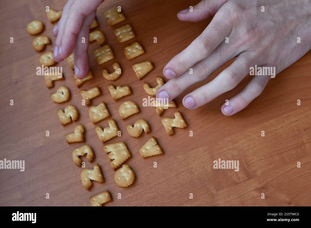 Mens fingers typing on the keyboard, which is composed of salty cracker ...