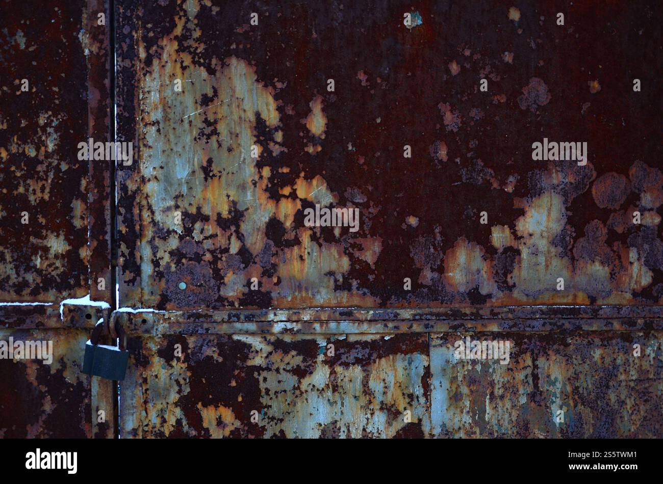 The texture of the gate of rusty metal with flaky granary lock hanging ...