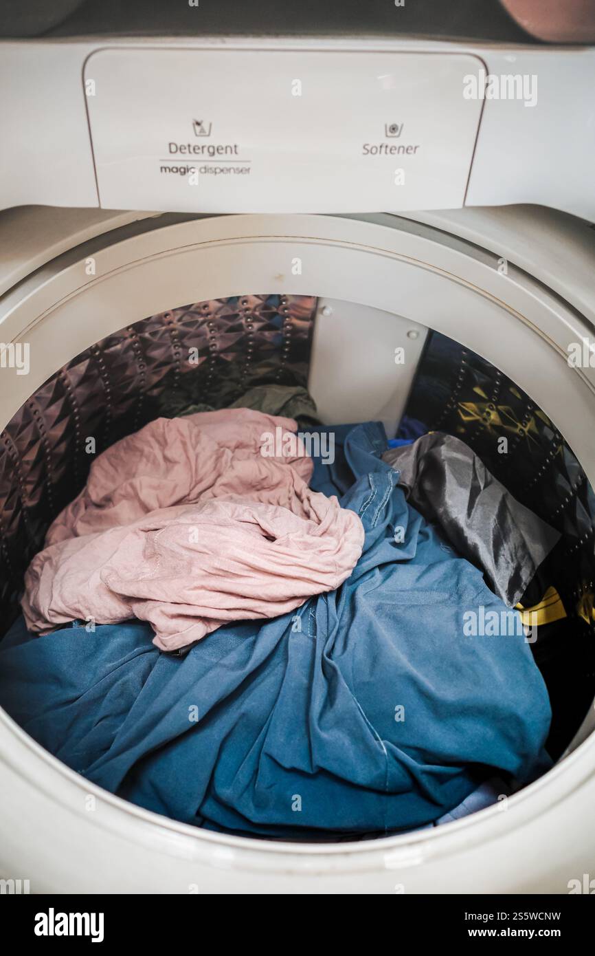 Heap of laundry inside of top loading washing machine Stock Photo