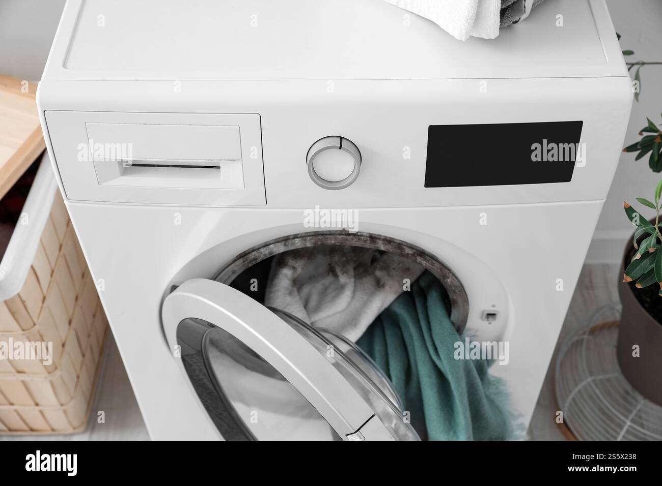 Washing machine with black mold and clothes in laundry room Stock Photo