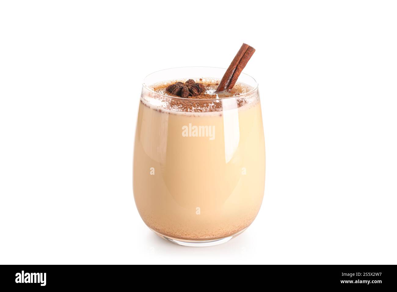 Glass of tasty eggnog cocktail with star anise and cinnamon on white ...