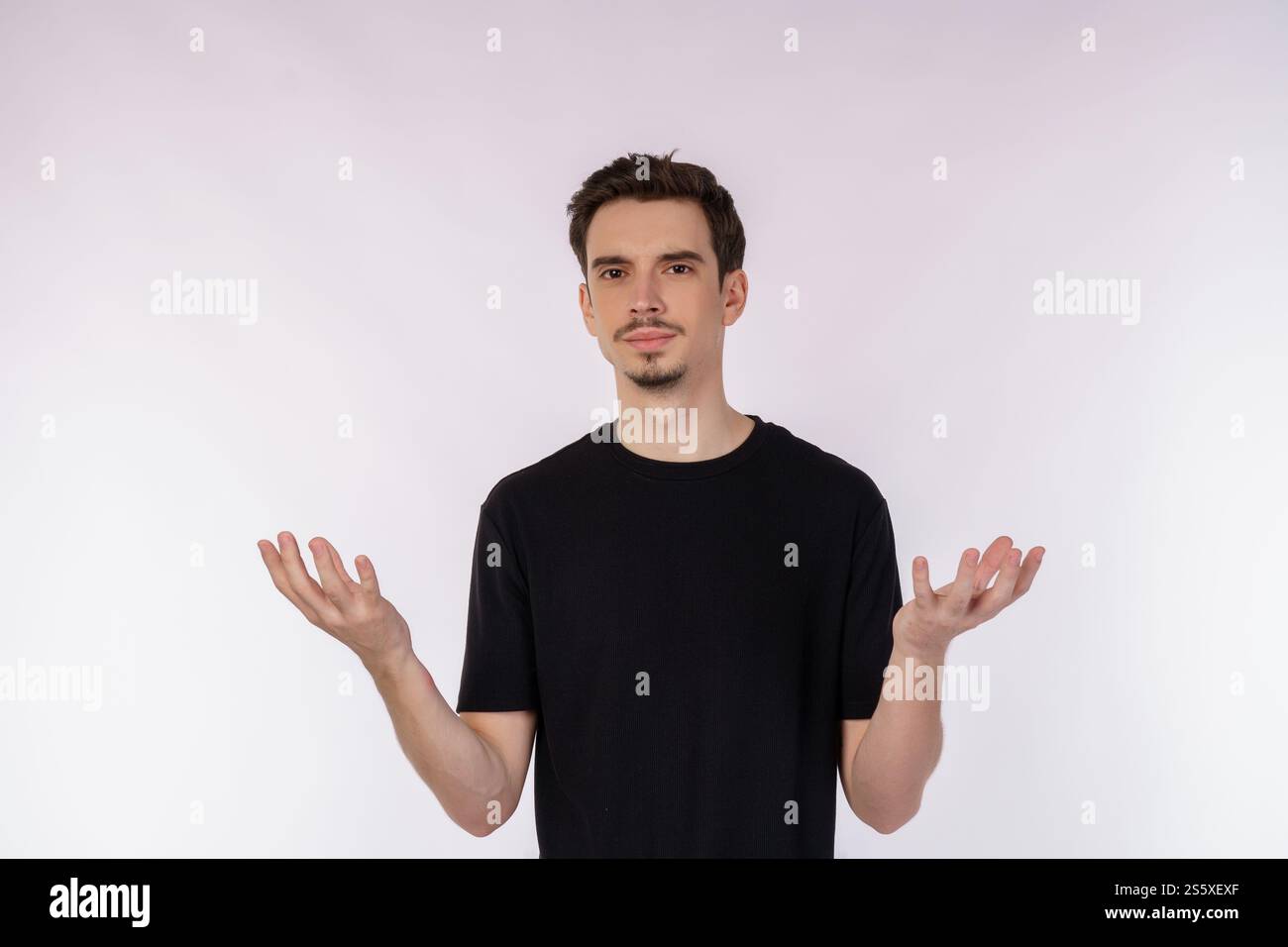Portrait of puzzled clueless young man arms out asking why whats the problem who cares so what, I dont know on isolated background. Stock Photo