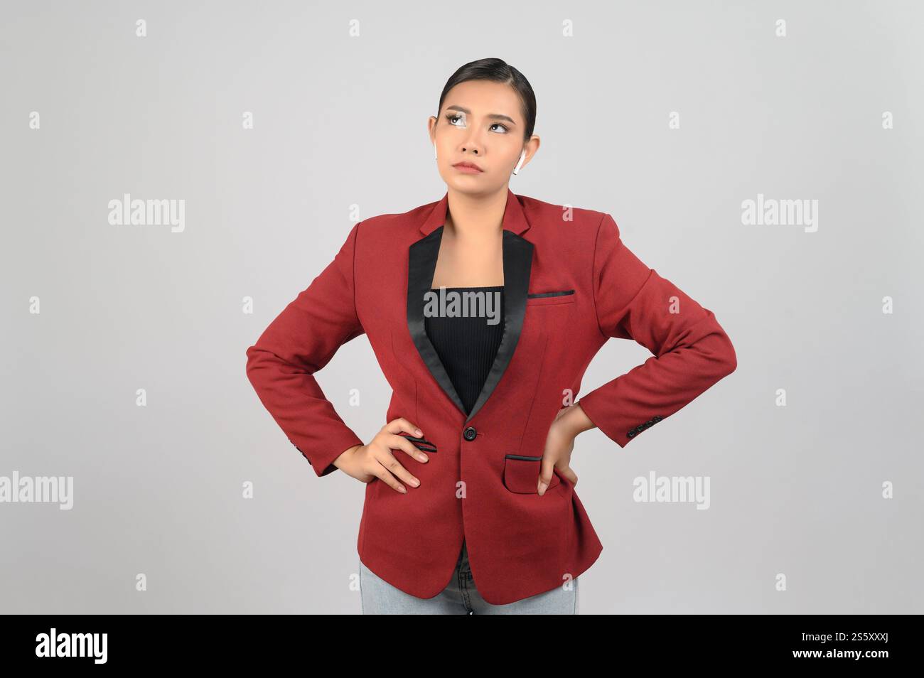 Portrait of young asian woman in officer costume standing on waist and her face thoughtful. free space to put products for advertisement isolated on Stock Photo
