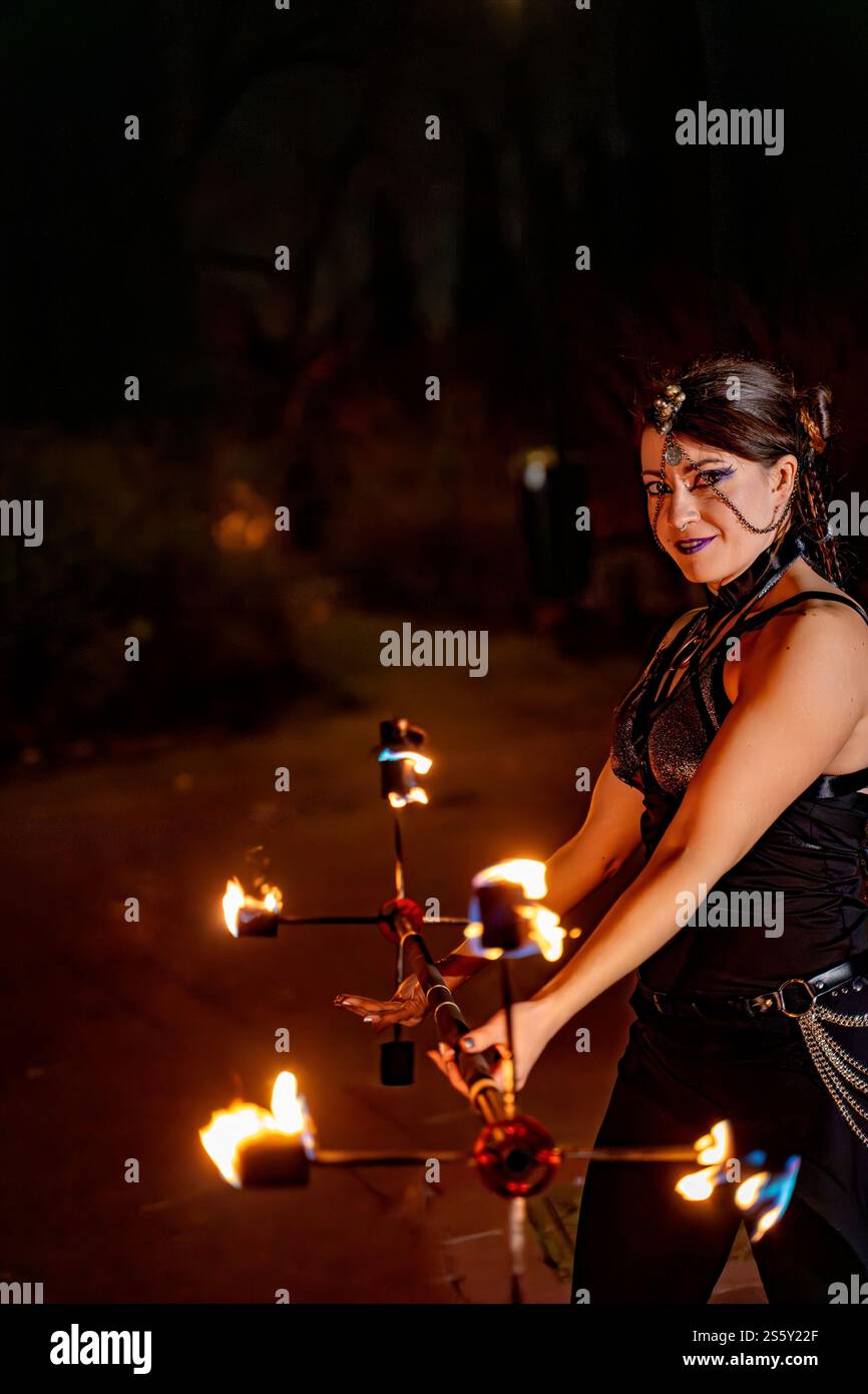 Professional fire artist performing with flaming torches in evening ...