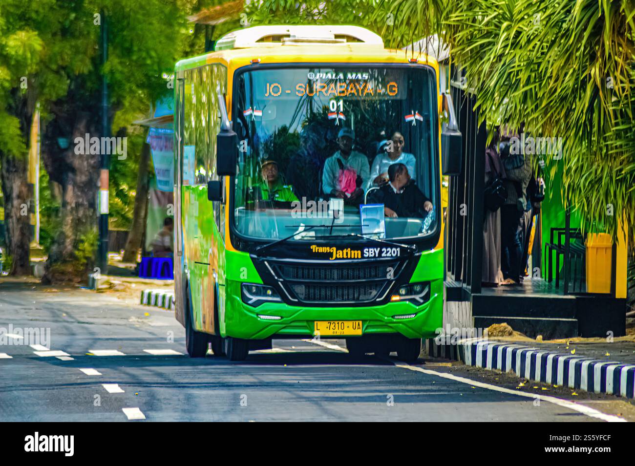 A green Trans Jatim Bus that stops at bus stops. Isuzu small town bus in Indonesia, 27 June, 2023. Stock Photo