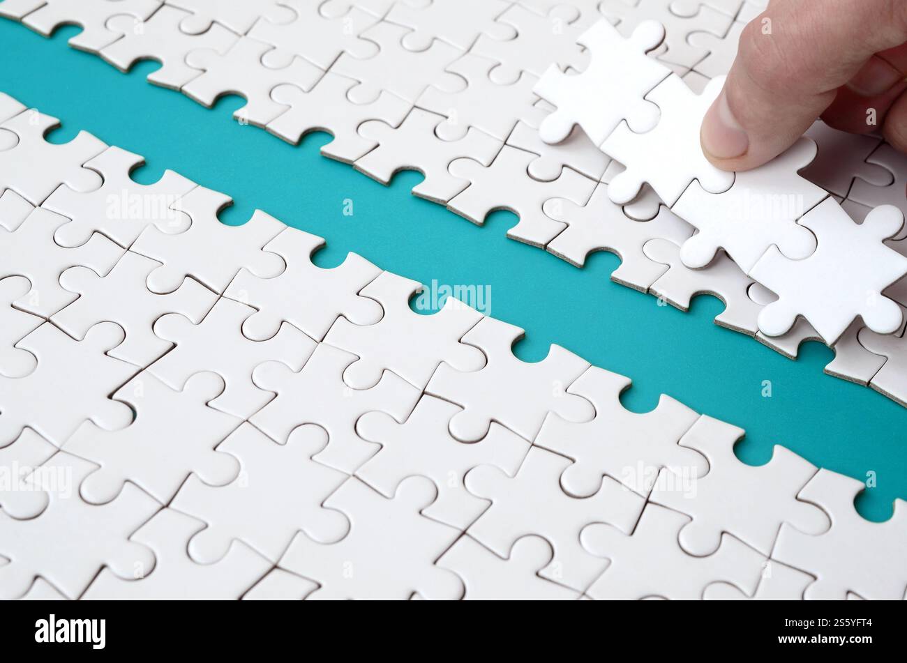 The human hand paves the way to the surface of the jigsaw puzzle The human hand paves the way to the surface of the jigsaw puzzle