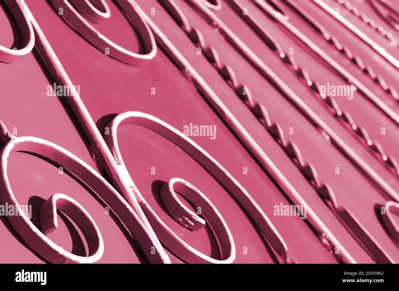 Metal texture of a piece of wall with a forged pattern. Image toned in Viva Magenta, color of the 2023 year. Metal texture of a piece of wall with a Stock Photo