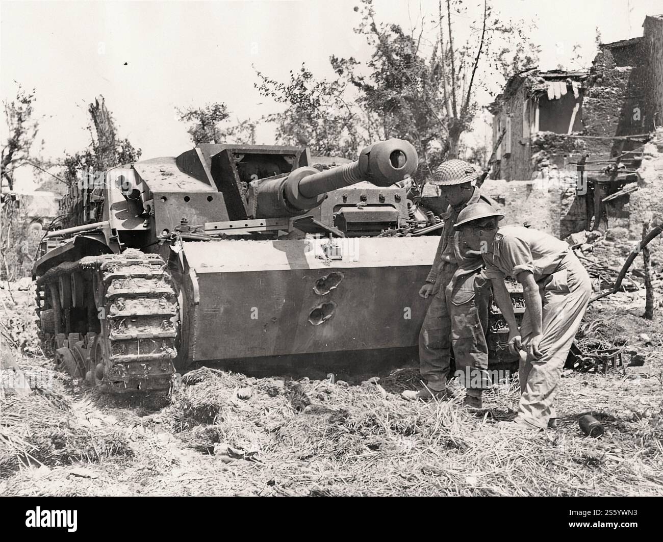 British soldiers look at the holes in the frontal armor of the German self-propelled gun StuG III ausf G. Italy, in May 1944. - Historical document, photographer unknow Stock Photo