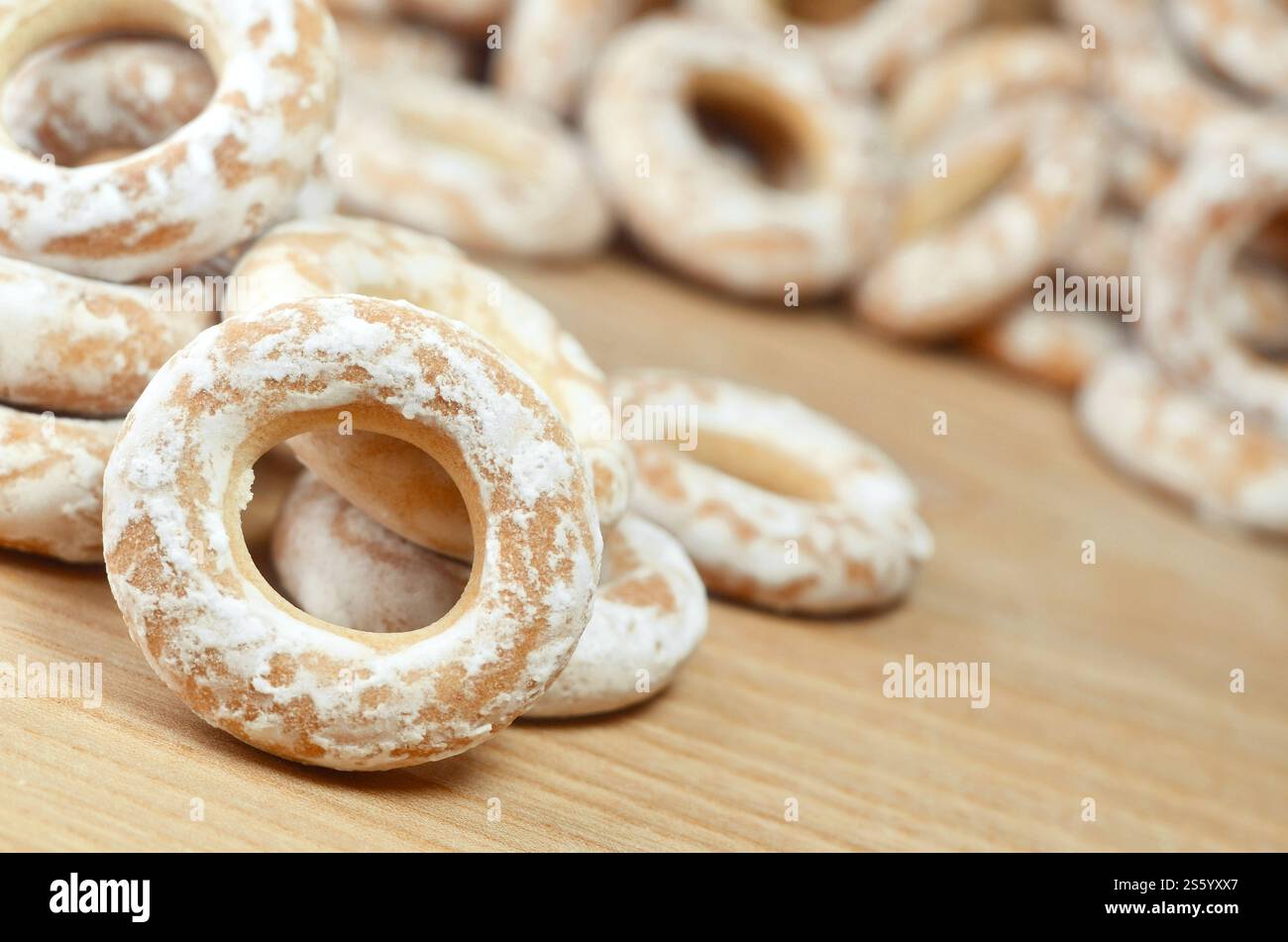 Still life of donut glaze on a wooden surface. Glazed bagels are a small bunch on a wooden table. Flour sweets to the Tea Party Stock Photo
