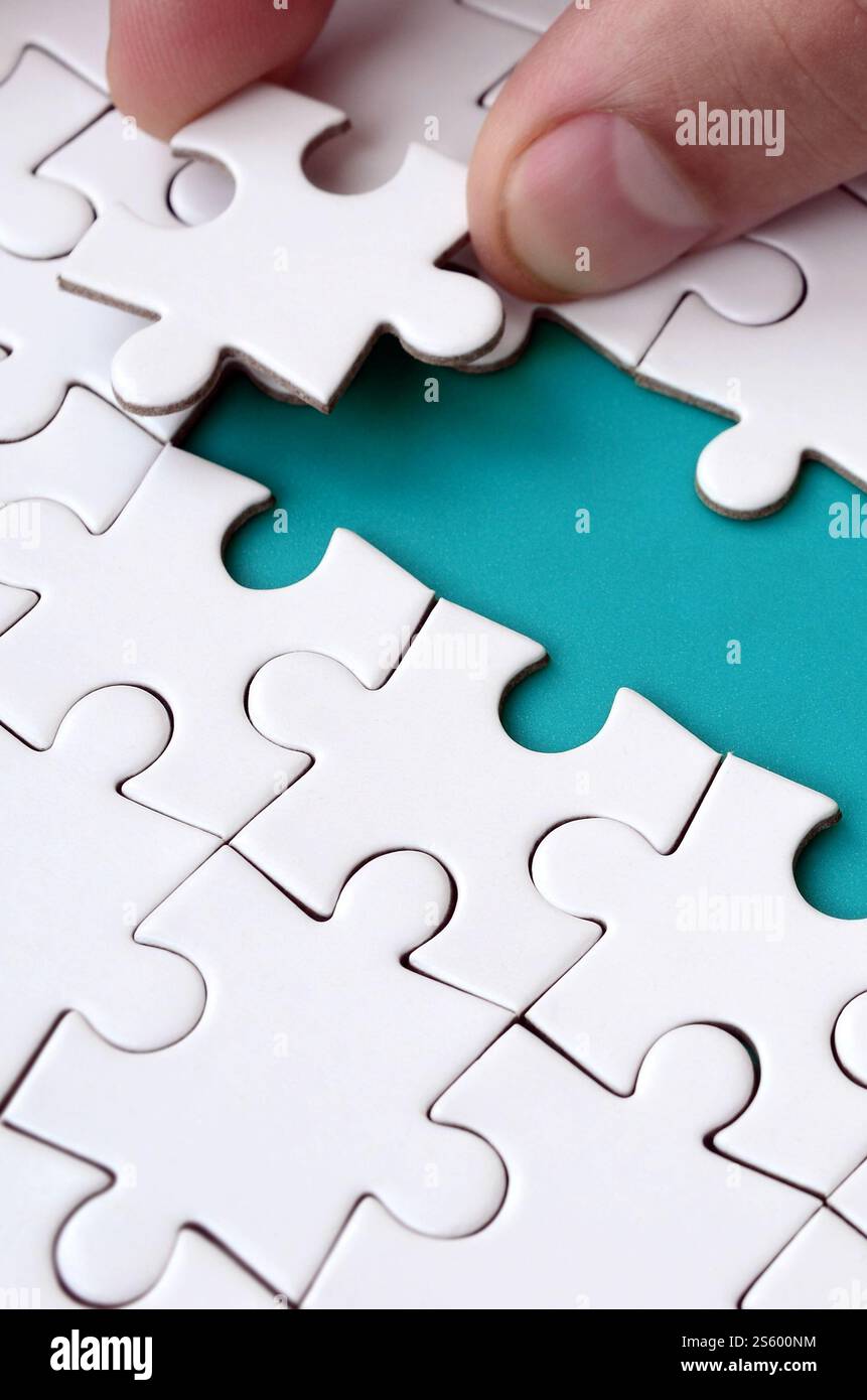 The human hand paves the way to the surface of the jigsaw puzzle The human hand paves the way to the surface of the jigsaw puzzle
