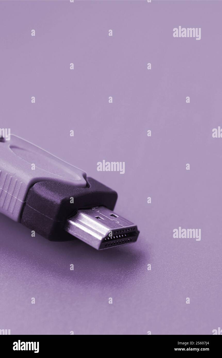 Black audio video HDMI computer cable on purple background. Close up of home entertainment connection cable for sound and video. Black audio video Stock Photo