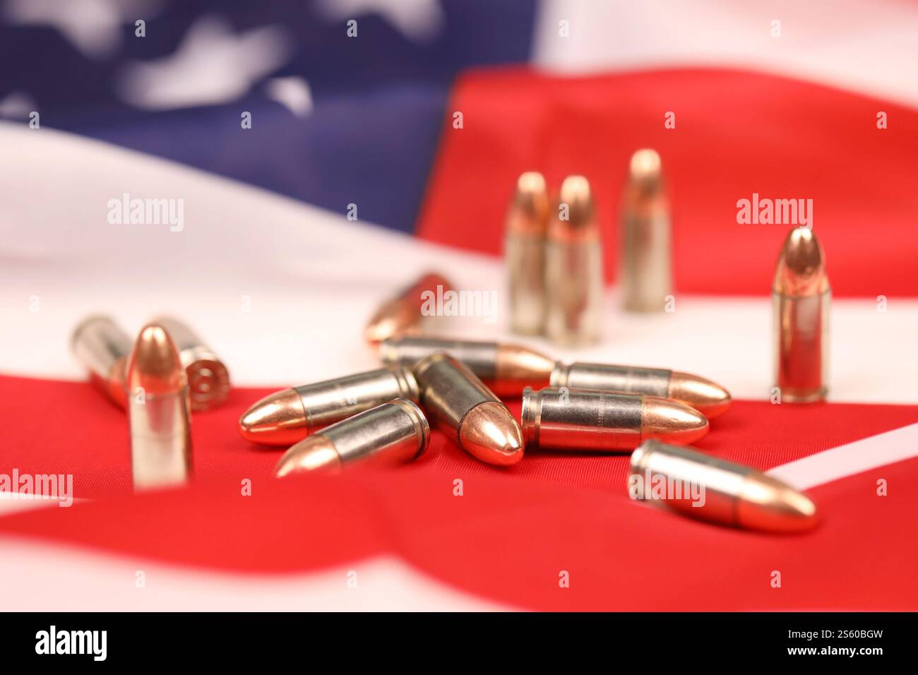 Many yellow 9mm bullets and cartridges on United States flag. Concept of gun trafficking on USA territory or special operations. Many yellow 9mm Stock Photo